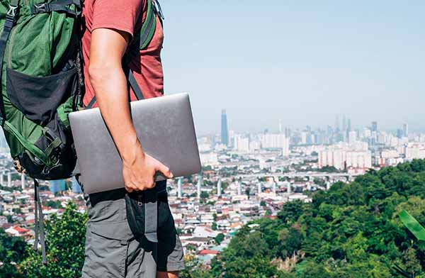 No Office Required: Man with backpack and laptop in urban environment