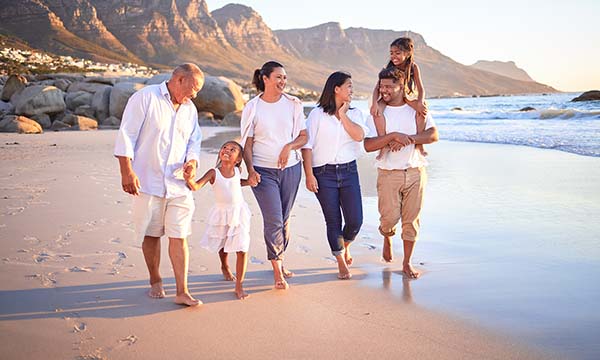 Multigenerational Trip Ideas: Family Walking On Beach