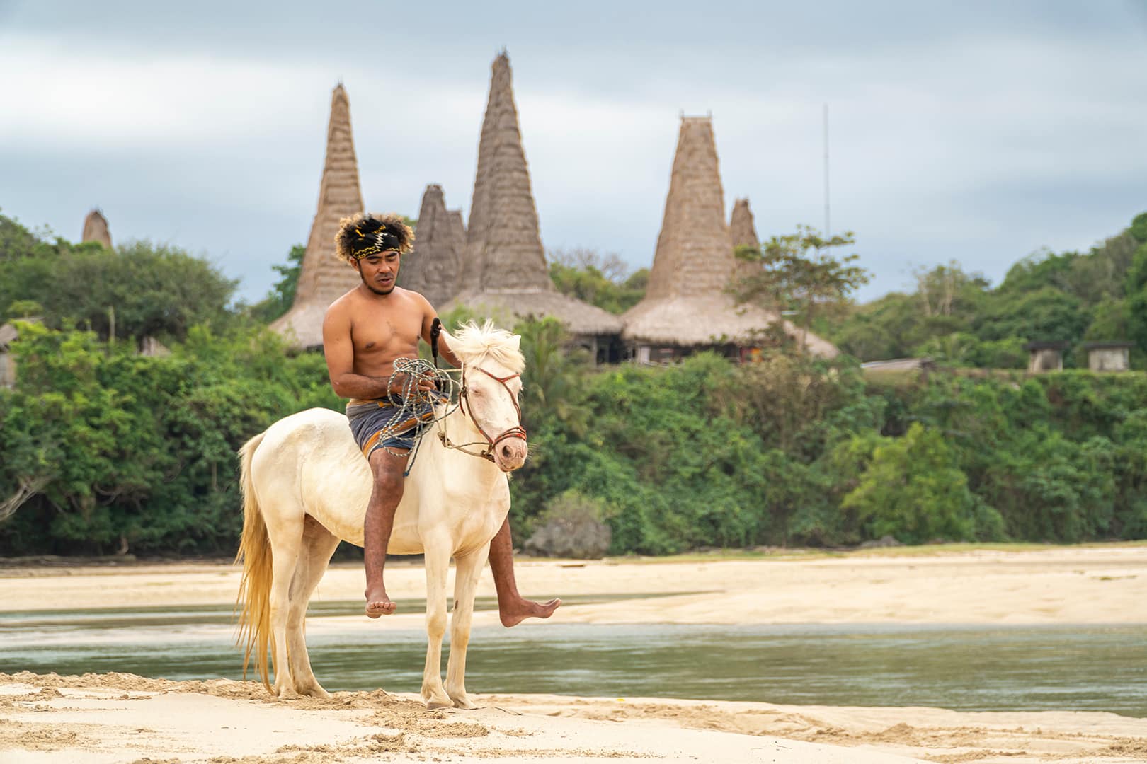 destination duping Marapu Sumba Tribe gracefully rides a horse along the shoreline